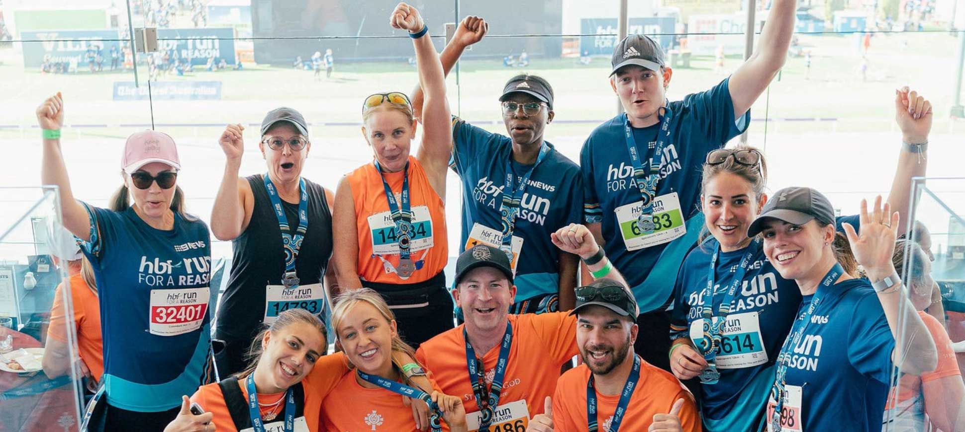 St John of God Foundation team hold their arms up in celebration at completing the HBF run for a reason