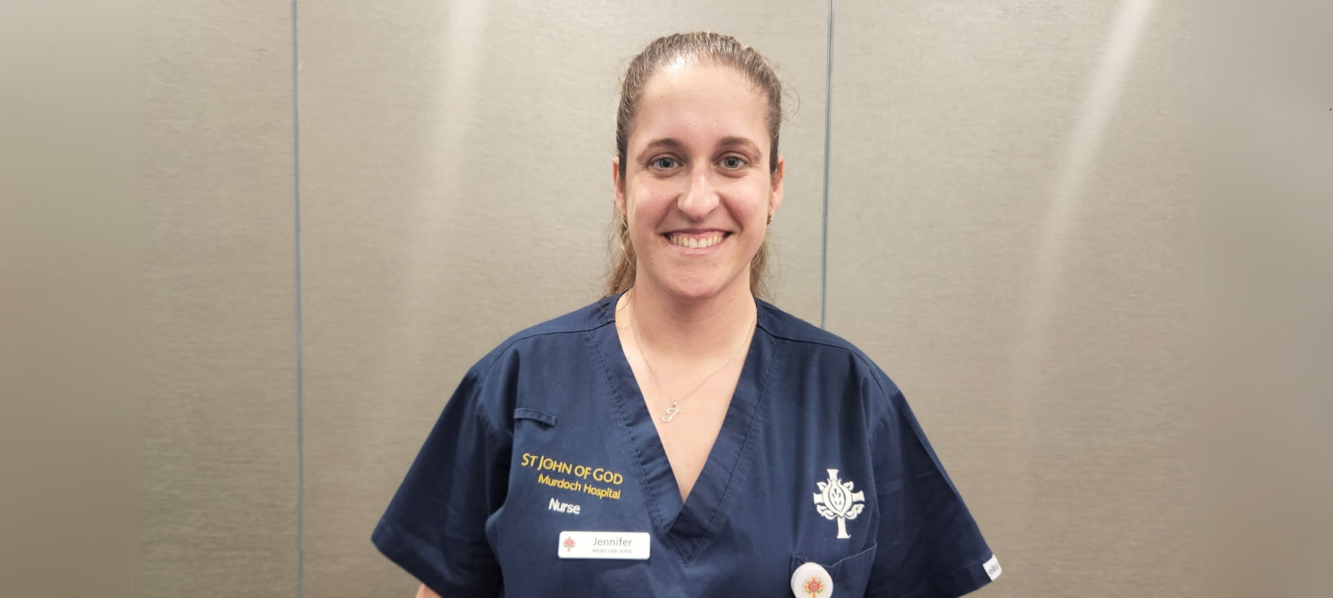 Breast Care Nurse Jennifer Mager smiles for a phot wearing her scrubs