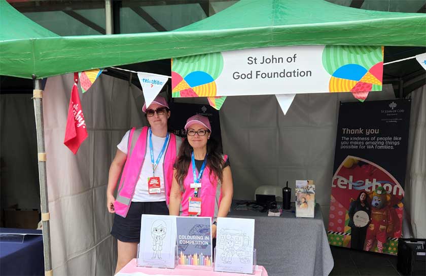 Caregivers smile for a photo at the St John of God Froundation booth